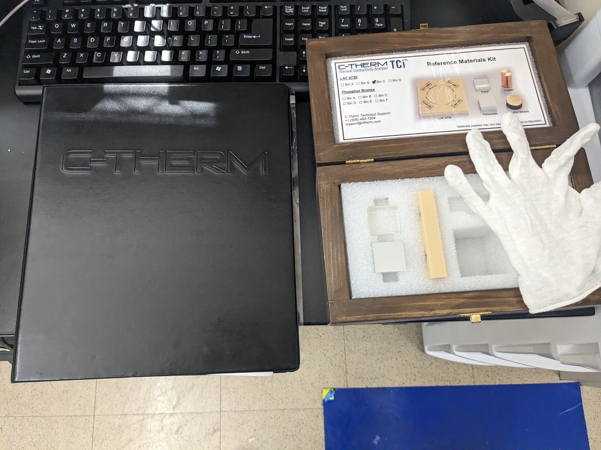 C-Therm manual next to wooden box containing reference samples and glove